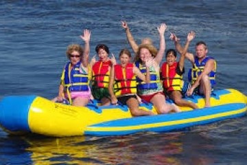 a group of people riding on the back of a boat in the water